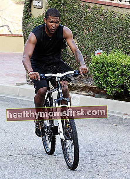 Usher naik sepeda